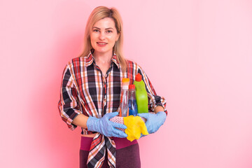 Wall Mural - Beautiful blonde woman holding basket and detergent bottle.