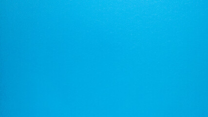 Top view of the turquoise surface of the lake water. A small ripple from the waves and a slight gradient from light blue to dark blue. Photo as a background. Clean water. Kolsai Lake, Kazakhstan