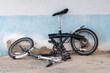 Bicycle with a frame broken in half stands against the wall