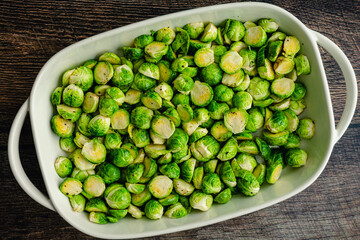 Canvas Print - Overhead View of Halved Brussels Sprouts Tossed in Extra Virgin Olive Oil: A baking dish full of raw Brussels sprouts cut in half and tossed in olive oil, salt and pepper