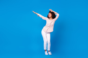 Wall Mural - Full length photo of shiny positive lady wear pink shirt smiling dancing isolated blue color background