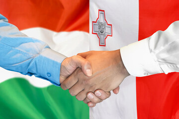 Wall Mural - Handshake on Hungary flag and flag of Malta background. Support concept