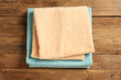 Soft folded colorful terry towels on wooden table, top view