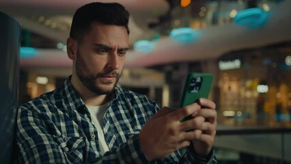 Concentrated pensive caucasian hispanic businessman thinking worker serious man looking at mobile phone screen texting message typing on smartphone chatting online app buying goods in shopping center