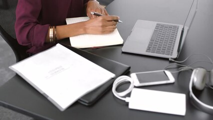 Wall Mural - Creative professional taking notes and brainstorming ideas for a new design project of opportunity. Aerial closeup of a business woman writing in her notebook while working at her desk in the office