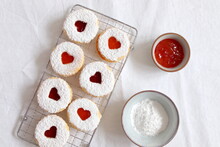 Christmas Linzer Cookies With Heart Cutouts, Currant Jam And Powdered Sugar On A White Linen Tablecloth