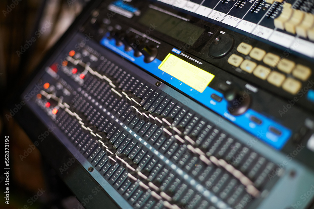 Multichannel sound mixer console board isolated with clipping path. Professional audio mixing console with faders and adjusting knobs. Audio mixing board, professional audio mixing console