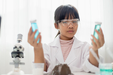 education, science, chemistry and children concept - kids or students with test tube making experiment at school laboratory