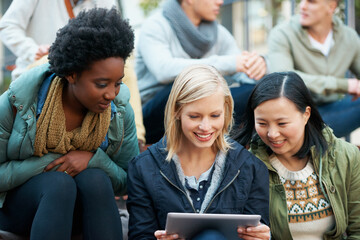 Sticker - Look at this. Shot of a group of university students looking at something on a digital tablet.