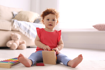 Sticker - Cute little child playing with toys on floor at home