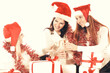 © yurolaitsalbert - closeup.three young women in hats of Santa Claus with Christmas gifts and glasses of champagne .
