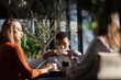 © Nikola Spasenoski - Three friends in a restaurant talking smiling and drinking tea. Business colleagues having a meeting after work or during coffee break at a cafe bar.