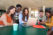 © CarlosBarquero - Group of students, high school pupils gather in college cafeteria, discuss topics, work together on creative task, prepare for university test or exams use laptop. Education study, modern tech concept