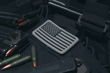 tactical equipment in black with an american flag patch and magazines with cartridges from ak47, clo