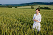 © volody10 - Scientist technologist in a white coat on a young wheat field writes down data on this year's crop on a smart tablet
