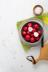 Wall Mural - Red radish in bowl cooking food  sliced on cutting board spring salad