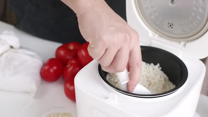 Wall Mural - Smart home devices. man cooking rice using Electric rice cooker