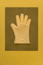 Yellow Heat Resistant Glove On Kitchen Mesh Mat Flat Lay