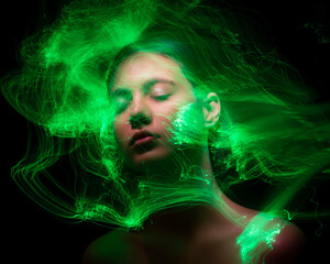 Wall Mural - Abstract photography in the style of light painting. girl on a black background	