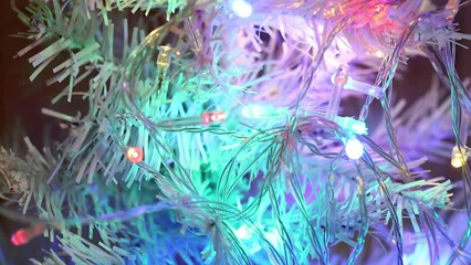 Poster - multi-colored flashing garland on the branches of a white Christmas tree