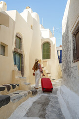 Wall Mural - Young woman with a red suitcase travels