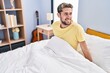 © Krakenimages.com - Young man smiling confident sitting on bed at bedroom