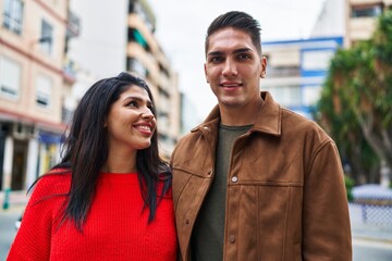 Poster - Man and woman couple smiling confident hugging each other at street