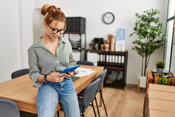 Poster - Young caucasian woman business worker smiling confident using touchpad at office