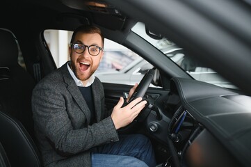 Handsome businessman driving car before buying