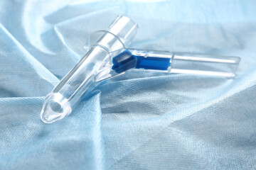 Anoscope on light blue fabric. Hemorrhoid treatment