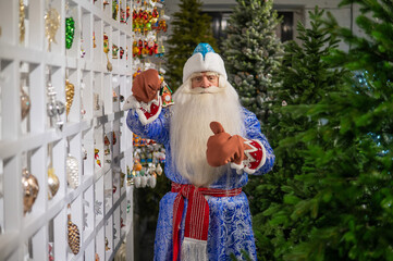 Russian Santa Claus chooses decorations for the Christmas tree in the store.