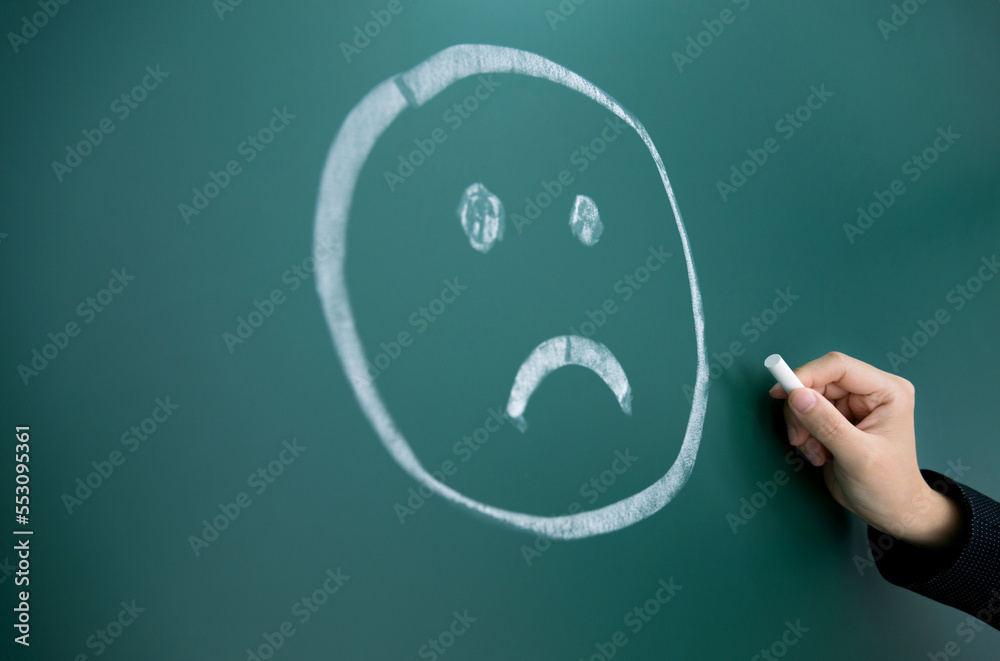 Hand drawing sad face on background