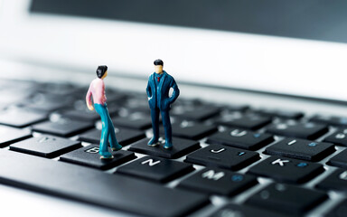 miniature workers standing on top of keyboard