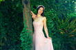 Young woman in a pink dress in nature