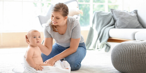 Wall Mural - Mother wiping her cute little baby after bathing at home