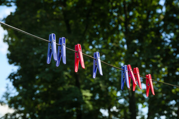 Wall Mural - Many colorful clothespins hanging on rope outdoors