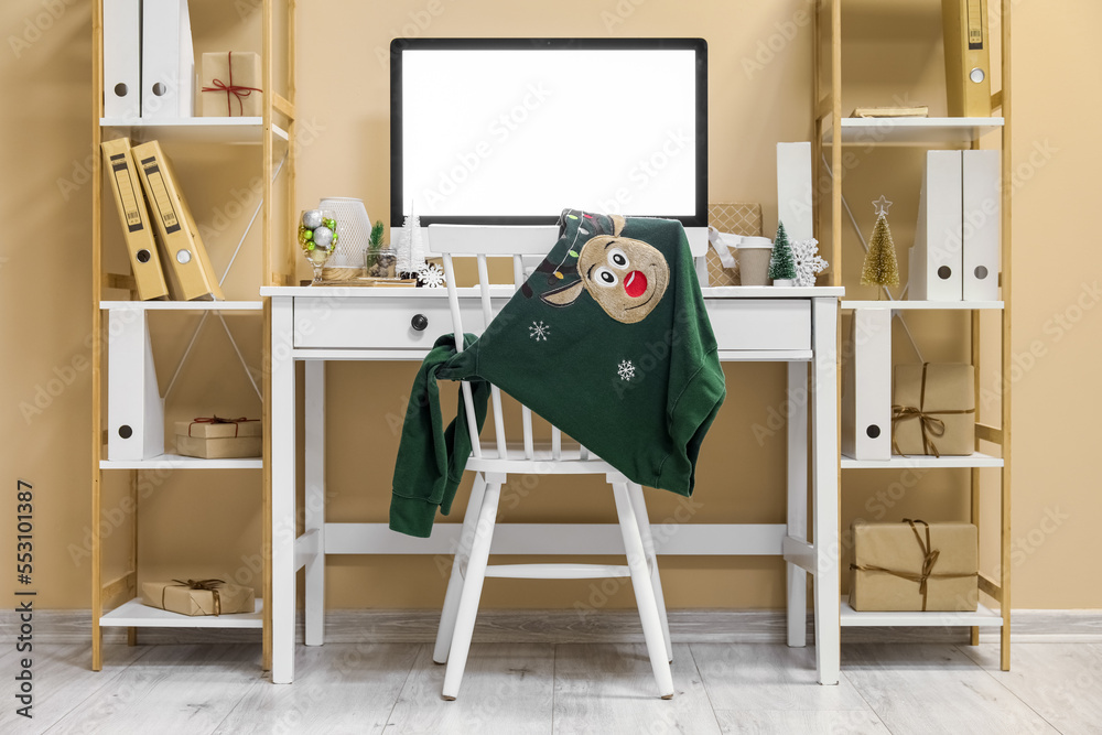 Interior of light office with workplace, shelving units and Christmas decor