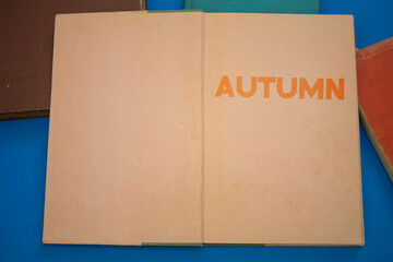 Poster - Autumn word in opened book with vintage, natural patterns old antique paper design.