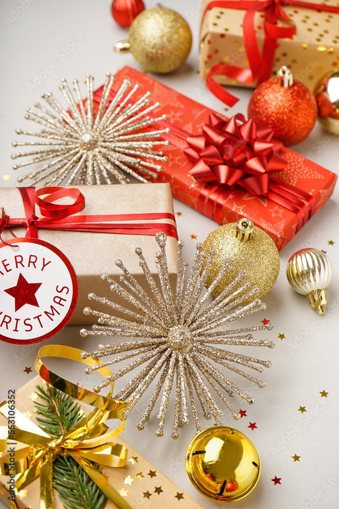 Gift boxes with Christmas toys on light background