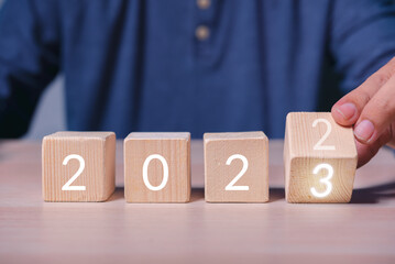 Aufkleber - hand build stack of wood cube building block with text 2023 , new year 2023 plan concept