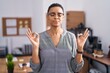 © Krakenimages.com - African american woman working at the office wearing glasses relax and smiling with eyes closed doing meditation gesture with fingers. yoga concept.