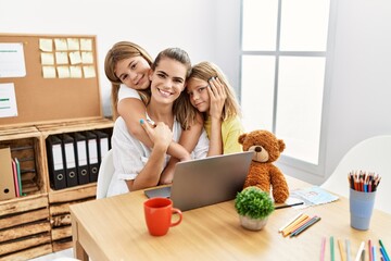 Wall Mural - Mother and daughters smiling confident hugging each other working at office