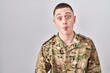 © Krakenimages.com - Young man wearing camouflage army uniform making fish face with lips, crazy and comical gesture. funny expression.