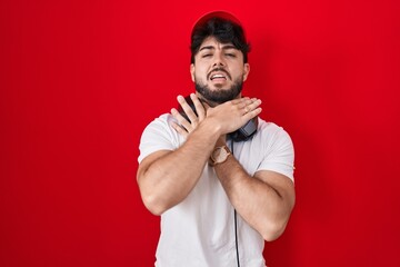 Poster - Hispanic man with beard wearing gamer hat and headphones shouting suffocate because painful strangle. health problem. asphyxiate and suicide concept.