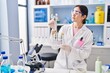 © Krakenimages.com - Young woman wearing scientist uniform holding test tubes with flowers at laboratory