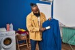 © Krakenimages.com - Young african american man cleaning clothes using pet hair roller at laundry room
