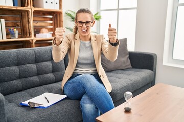 Canvas Print - Young woman working at consultation office angry and mad raising fists frustrated and furious while shouting with anger. rage and aggressive concept.