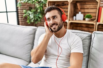 Canvas Print - Young hispanic man smiling confident listening to music at home