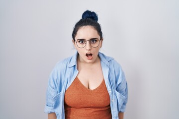 Poster - Young modern girl with blue hair standing over white background afraid and shocked with surprise and amazed expression, fear and excited face.