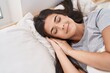 © Krakenimages.com - Young beautiful hispanic woman lying on bed sleeping at bedroom